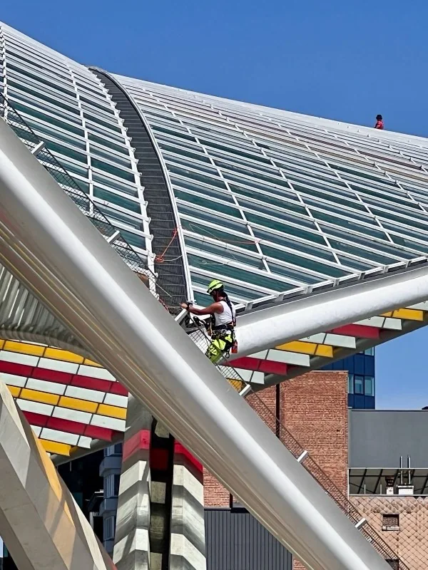 Maintenance technician performing scheduled upkeep on a rooftop facility structure
