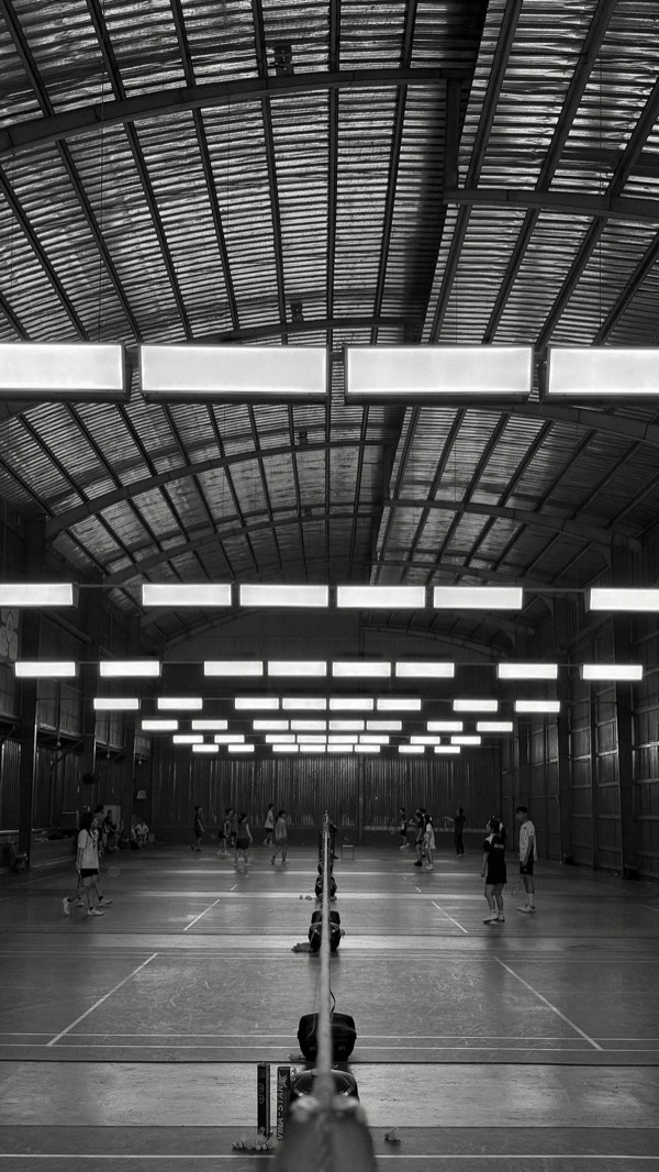 Players competing on a busy indoor badminton court