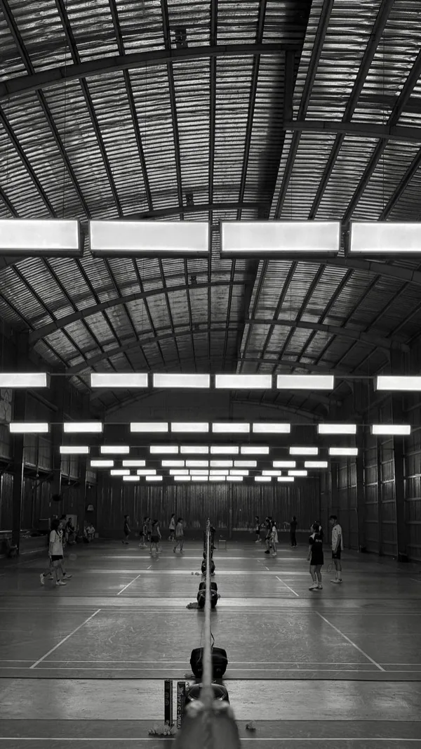 Players competing on a busy indoor badminton court