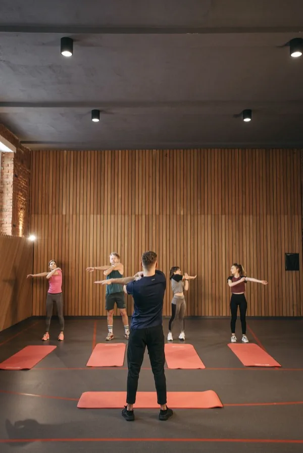 Group fitness class stretching together indoors, led by an instructor