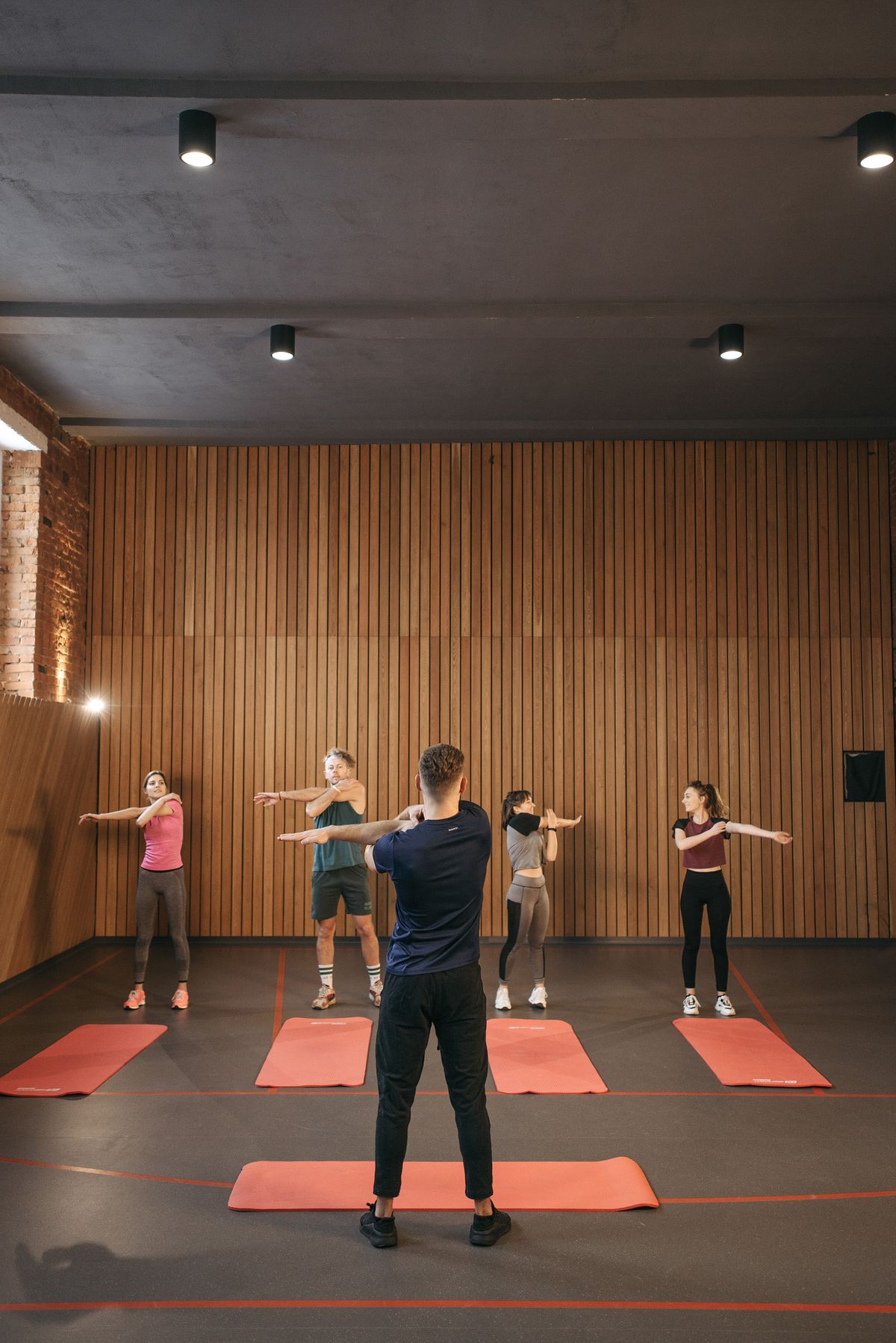 Group fitness class stretching together indoors, led by an instructor