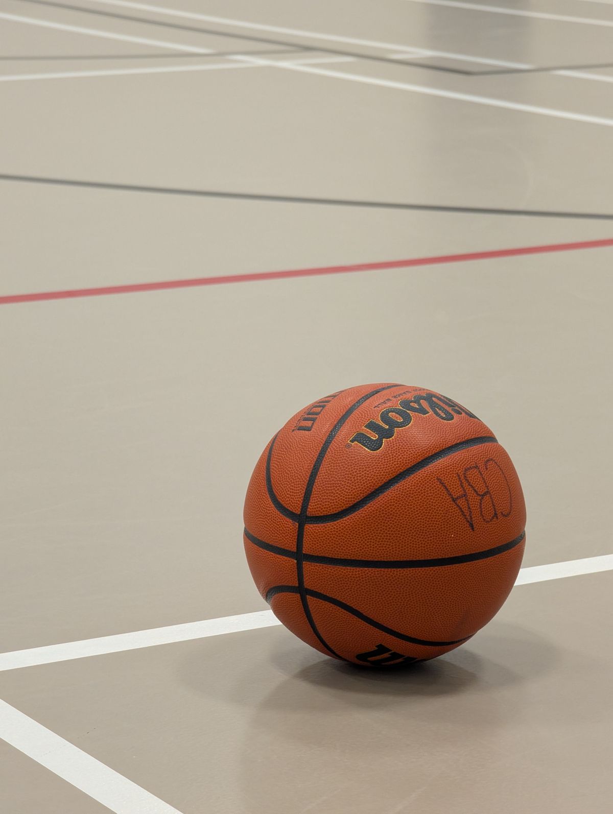 Basketball resting on an indoor court with clean white line markings