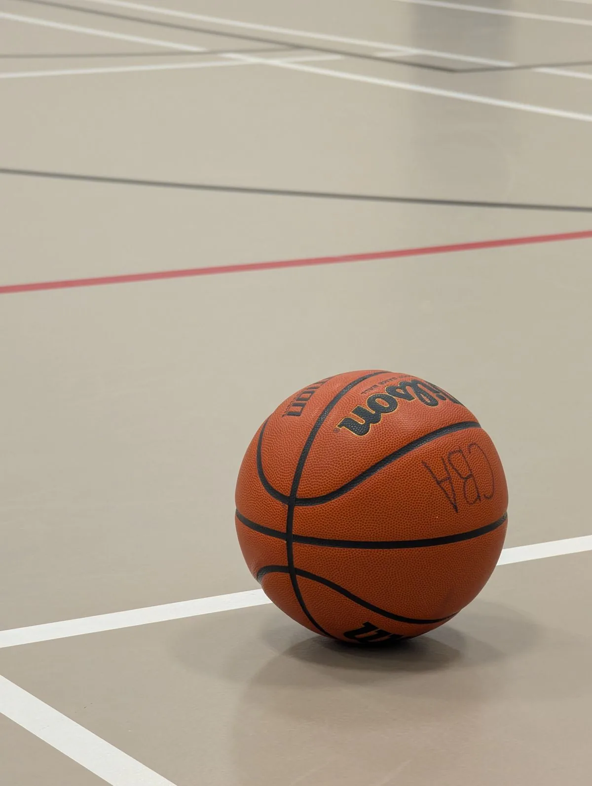 Basketball resting on an indoor court with clean white line markings