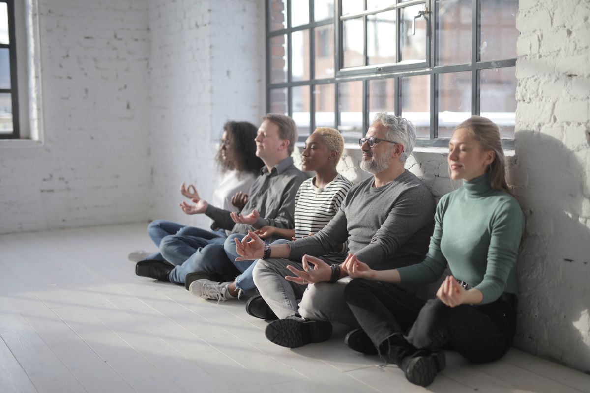 Diverse group of coworkers taking a mindful break together in a modern office