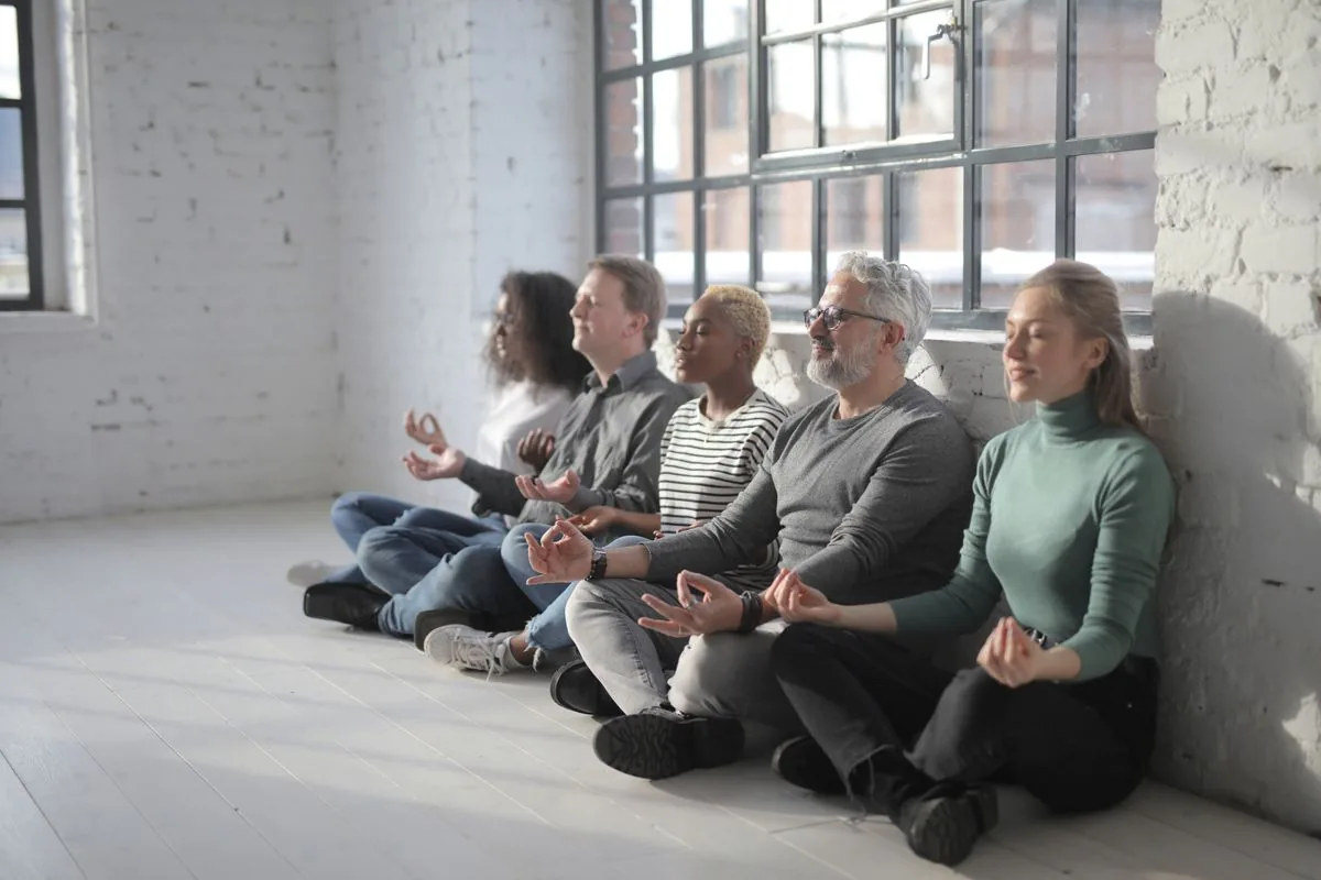 Diverse group of coworkers taking a mindful break together in a modern office