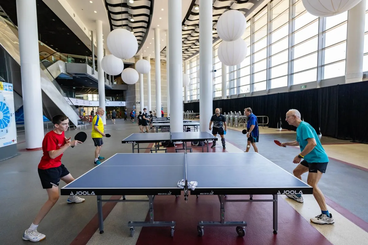 Players competing at a table tennis table inside a modern indoor sports venue