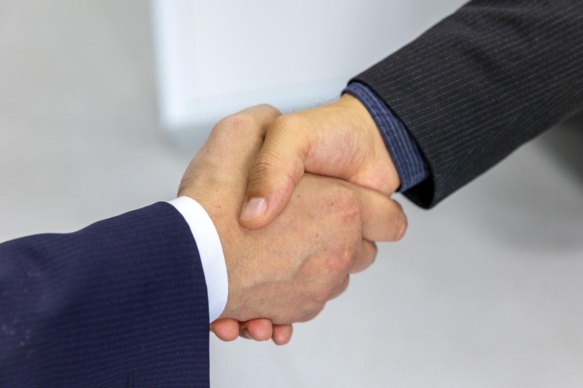 Two business professionals shaking hands after a vendor agreement