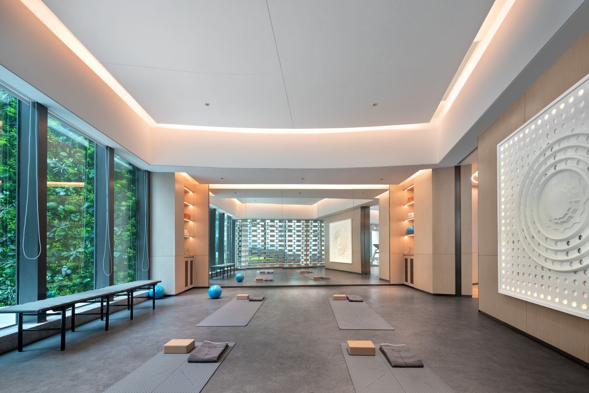 Bright modern yoga studio interior with wooden flooring and yoga mats