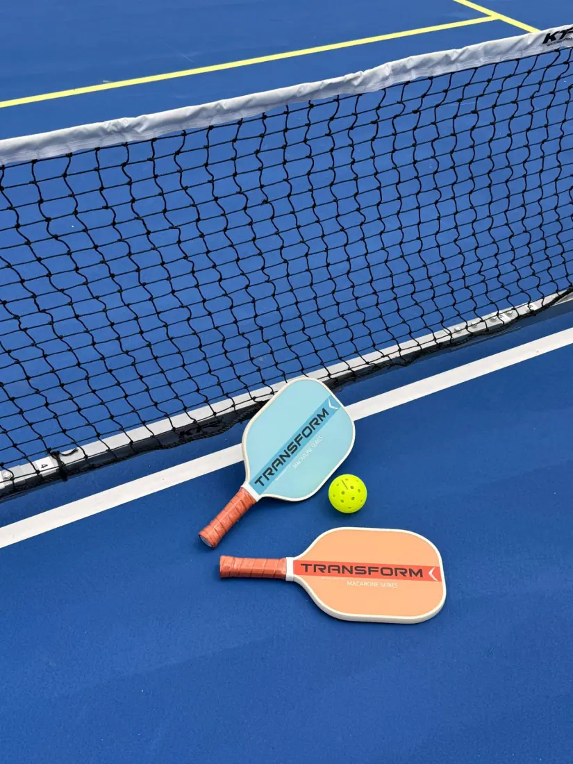 Pickleball net, paddles and ball on the resurfaced acrylic court surface