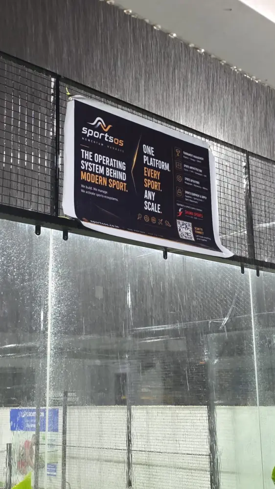 sportsOS sponsorship banner on the padel court enclosure during heavy rain